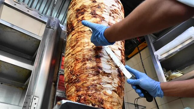4k: Chef cutting the meat, Preparation of chicken shawarma sandwich, doner kebab, the most popular Arabic-Turkish street food in the world
