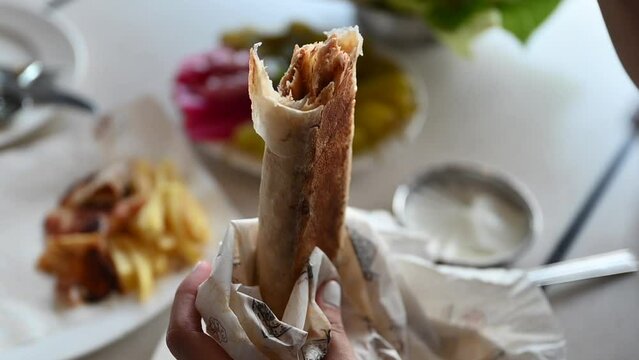 A lady shows the chicken Shawarma, a closeup of chicken shawarma the most popular Arabic-Turkish street food.
