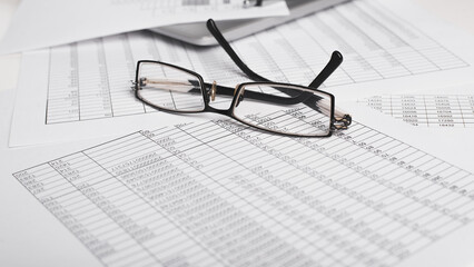 Documents, bills and eyeglasses at the workplace. Close-up, selective focus, low angle view