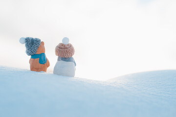 christmas card. Statuette figurine of two snowmen beanie on a snowy background outdoors.