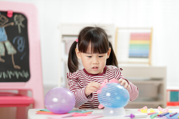 young girl making balloon craft for home schooling