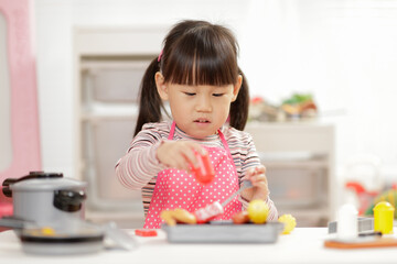 young  girl pretend play food preparing at home