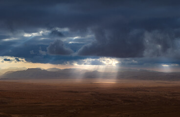 Storm clouds with sun rays in the Wadi Rum desert valley in Jordan