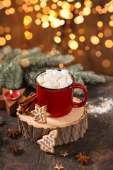 Red mug of hot cocoa with marshmallows and homemade Christmas gingerbread cookies. Christmas...