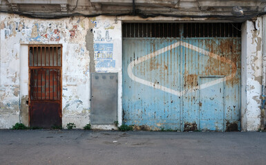 Weathered door to a garage of an abandoned building in Valencia Spain