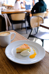 おしゃれなカフェでチーズケーキとカフェラテを楽しむ様子