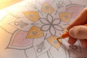 Woman coloring antistress page. Female hand painting mandala. Female painting mandalas to combat...