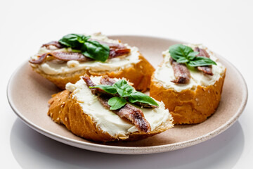 sandwich with anchovy fillets on a serving tray on a white background