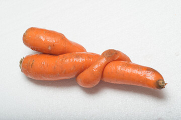 Deformed carrot on white background. Crooked and funny ugly vegetable with strange shape.
