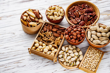 set of different nuts on a white wooden rustic background