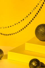 Yellow podium of gift boxes for product display, beads. Christmas background with Golden balls....