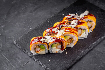 delicious sushi rolls on a black stone background
