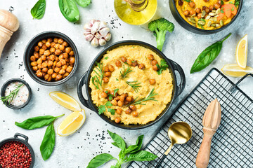 A bowl of hummus. Chickpea hummus and olive oil with spices. Top view. On a concrete background.