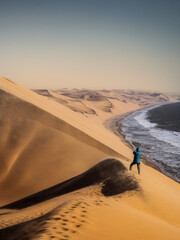Tourist takes a photo of landscape on wild coast of Sandwich Harbour on bad weather, Namibia....