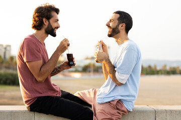 Gay couple embracing and showing their love. Young men drinking juice.