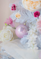 White Christmas tree decorated with roses and balls