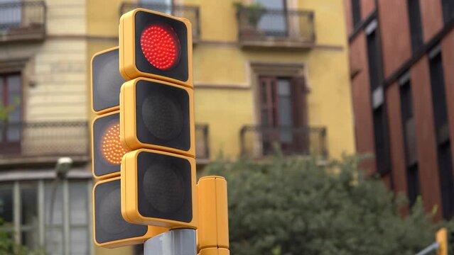 Yellow street traffic light changing the color on crosswalk in Barcelona, Spain