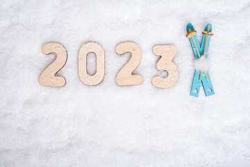 Sports year 2023. Bright blue wooden toys ski and date 2023 on white snow, flat lay, copy space....