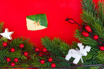 Weichnachtsplätzchen für einen Kalender mit einer Zahl (16) vor rotem Hintergrund