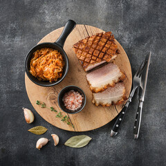 Crispy Roast Pork Belly with stewed cabbage on wooden cutting board