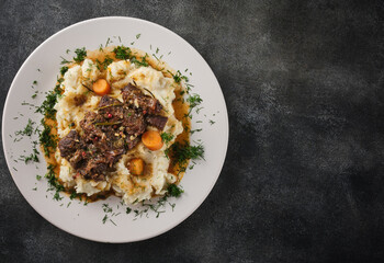 Beef cheeks with mashed potatoes on white plate.