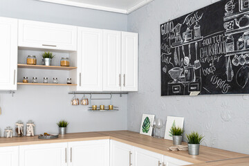  modern fancy white kitchen with potted home plants and black chalk board with drawings on the wall
