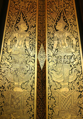 Fototapeta na wymiar Incredible Gilded Black Lacquer Door Panel of the Ordinary Hall of a Buddhist Temple in Thailand 