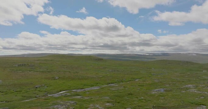 Aerial view over Hardanger Plateau with wild green landscape, beautiful sky