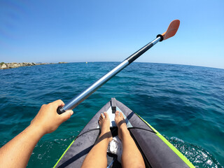 Woman driving a kayak in blue waters. Sports POV photography.