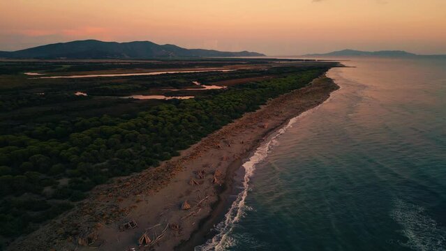 Tuscany seaside Cinemagraph seamless video loop in Italy by sunset in nature. Bird view aerial drone flight above a natural tourist vacation sea coast sand beach sandy bay with clear blue water in 4K.