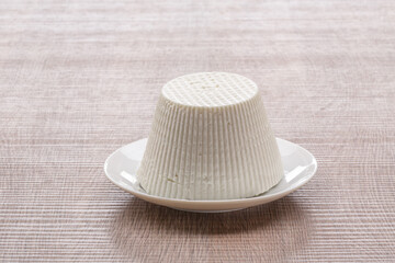 cottage cheese on white plate with wooden background