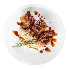 Plate of gourmet grilled beef ribs with sauce and garnish