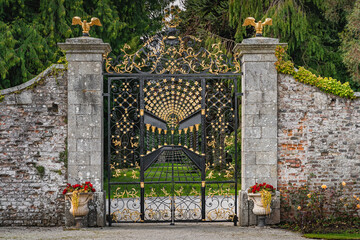 Beautiful, ornate wrought iron gate with golden details in Powerscourt gardens, Wicklow, Ireland....