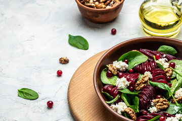 Fototapeta na wymiar Healthy Beet Salad with fresh sweet baby spinach, cheese, nuts, cranberries on a dark background. place for text, top view