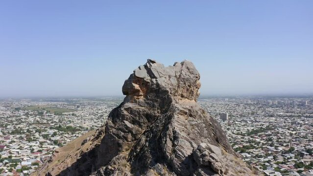 The rocky peak of the sacred mountain Sulaiman-Too. The city of Osh from a bird's-eye view. View of the amazing mountains. Beautiful nature of Kyrgyzstan.