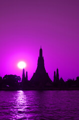 Fototapeta na wymiar Pop Art Style Vibrant Purple Colored Wat Arun or The Temple of Dawn with Bright Sun on Chao Phraya Riverbank, Bangkok, Thailand