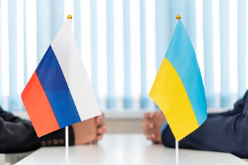 Close up of Russian and Ukrainian flags. Diplomats negotiate on war between Russia and Ukraine....