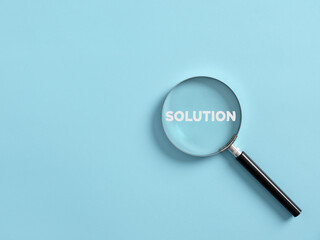 Magnifier focuses on the word solution. Searching for a business solution concept.