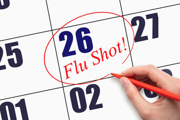 26th day of the month. Hand writing text FLU SHOT and circling the calendar date.