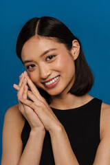 Portrait of young beautiful smiling asian woman with folded hands