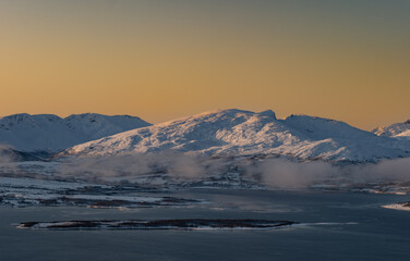Fototapeta na wymiar Sunset over the Norwegian fjord, winter photos at the golden hour, Tromso, Norway