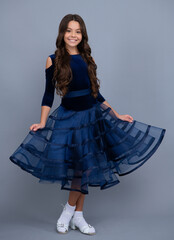 Happy girl face, positive and smiling emotions. Full length of beautiful teenage girl in dress standing and posing over gray background. Full length of teenager child wearing ball dress.