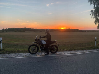 Obraz premium Motorradfahrer im Sonnenuntergang 