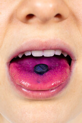 A person shows an indicator pill on his tongue to determine plaque.