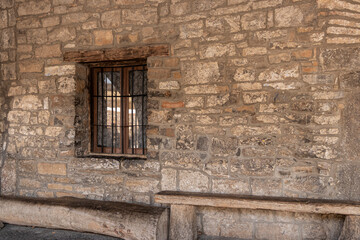 medieval barred window in a stone wall in the village of ainsa