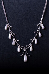 Fototapeta na wymiar necklace with white pearls stones on the black background
