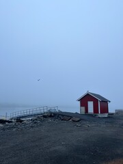 Small fishing house  in the fog by the sea