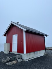 Small fishing house  in the fog by the sea