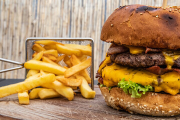 Cheeseburger with fries on a wooden board