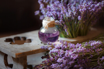 Obraz na płótnie Canvas Herbal oil and lavender flowers still-life on wooden background
